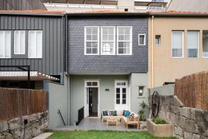 una casa con tetto nero e patio di Boavista Gem Villa a Porto