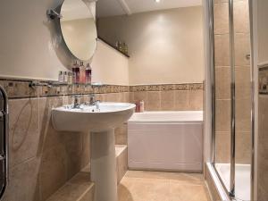 コニストンにある5 Bed in Coniston LCC28の洗面台、鏡、浴槽のあるバスルーム +14枚の写真