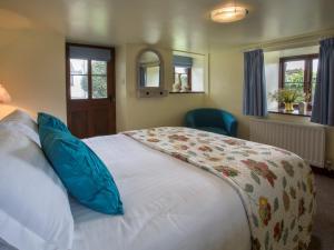 コニストンにある5 Bed in Coniston LCC28の大きな白いベッドと青い枕のある寝室