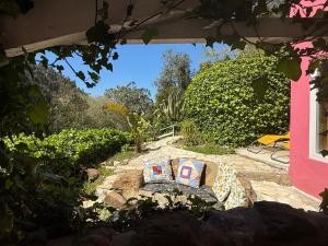 a patio with a table and chairs in a yard at Nativo Natureza Pink Wood Cabin in Cela +19 photos