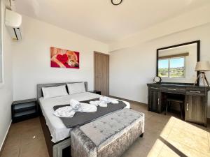 a bedroom with a bed and a desk and a mirror at STAY Symphony Apartment in Protaras +29 photos
