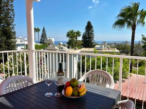 a table with a plate of fruit and a bottle of wine at STAY Symphony Apartment in Protaras