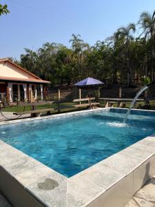 a swimming pool with a water fountain at Ninho de curiango in Índio