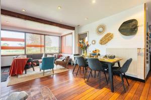 a living room with a table and chairs at La Maison Bateau au Bord de Mer in Guissény