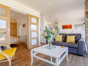 a living room with a couch and a table with flowers at 1 Bed in Weston-Super-Mare 78986 in Weston-super-Mare +18 photos