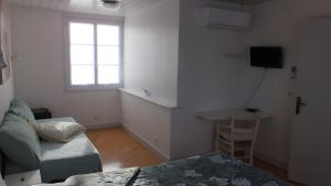 a living room with a bed and a window at Chambres d’hôtes Chantal Hereaudeau in Les Moulins de la Boire