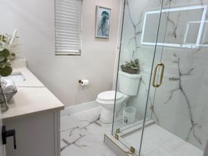 a bathroom with a toilet and a glass shower at Luxury Coastal Retreat in Largo +28 photos