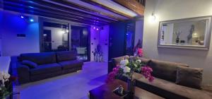 a living room with a couch and purple lighting at Cretan stars villas in Limín Khersonísou