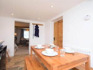 a wooden table with plates and glasses on top of it at 2 Bed in Appledore 53994 in Appledore