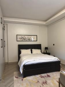 a bedroom with a large bed with a black headboard at Chic and Cozy studio Kyanja in Kampala