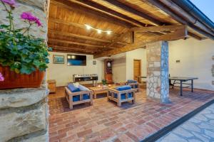a patio with a table and chairs and a stone wall at Casa Tereza in Mrgani