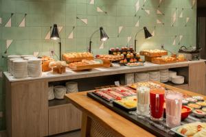 a buffet line with many different types of food at Intercity Porto Alegre Aeroporto in Porto Alegre