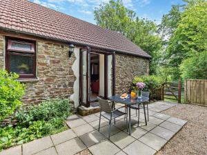 a small stone cottage with a table in front of it at 1 Bed in Bude WBARN in Sutcombe