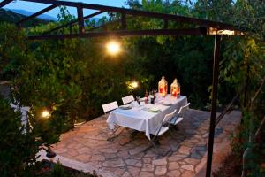 una mesa con un mantel blanco sentado en un patio en Apartments Villa Milna 1, en Budva