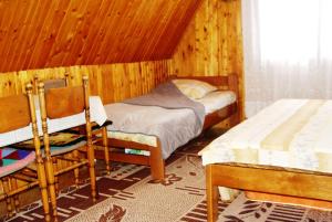 una camera con un letto e due sedie in una stanza di Guesthouse Durmitor Magic a Žabljak