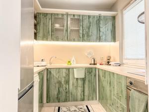 a kitchen with green wooden cabinets and a sink at 2BR Vintage Apt next to Tsar Simeon Garden by Flat Manаger in Plovdiv