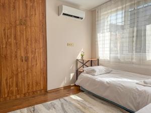 a bedroom with a bed and a large window at 2BR Vintage Apt next to Tsar Simeon Garden by Flat Manаger in Plovdiv