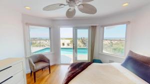 a bedroom with a bed with a ceiling fan and windows at Spectacular 8 Bedroom Oceanfront Hamptons Beach House, Your Castle By The Sea ! in Remsenburg +144 photos