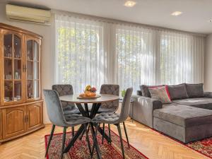 a living room with a couch and a table and chairs at 2BR Vintage Apt next to Tsar Simeon Garden by Flat Manаger in Plovdiv