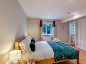 a bedroom with a large bed and two windows at 5 Bed in Witherslack SZ593 in Levens