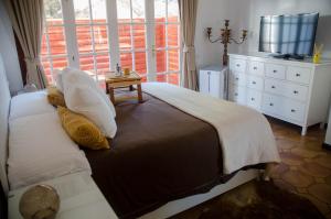 Schlafzimmer mit einem Bett, einem TV und einem Fenster in der Unterkunft Villa piscina privada MadreselvaSuite in San Bartolomé de Tirajana + 20 Fotos
