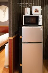 microondas en la parte superior de una nevera en una habitación en Prosper 5, 5th floor, 501 - Vacation STAY 73075v, en Nagoya