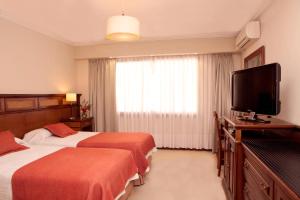 Habitación de hotel con 2 camas y TV de pantalla plana. en Ayres De Salta Hotel en Salta