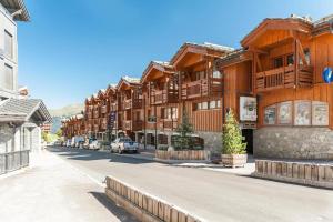a row of wooden buildings on a street at Résidence Les Chalets du Forum - Courchevel 1850 in Courchevel