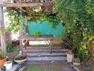 a wooden swing in a garden with a bench at Areco en lo de Lily in San Antonio de Areco