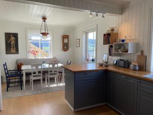 a kitchen with a table and a dining room at Koselig hus med stor og solrik hage in Lillehammer