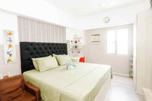a bedroom with a large bed and a chair at Sky's Cozy Nest in Cebu City