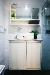 a bathroom with a sink and plants on a cabinet at Sky's Cozy Nest in Cebu City