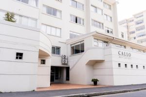 Un edificio blanco con el letrero de calicó. en Modern Apartment in Mouille Point with Green Point Park Access, en Ciudad del Cabo