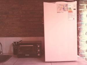 a refrigerator next to a toaster oven in a kitchen at Areco en lo de Lily in San Antonio de Areco