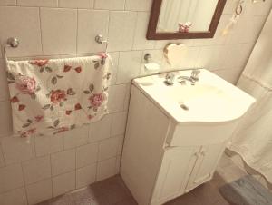 a white bathroom with a sink and a mirror at Areco en lo de Lily in San Antonio de Areco +22 photos
