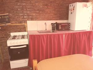 a kitchen with a table with a sink and a stove at Areco en lo de Lily in San Antonio de Areco