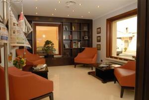 un soggiorno con sedie arancioni e finestra di Palazzo Foti Hotel a Crotone