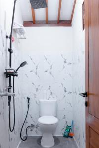 une salle de bain avec toilettes et douche dans l'établissement Homestay Pondok Jepun Banyuwangi, à Dadapan