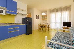 リニャーノ・サッビアドーロにあるAppartamenti Vacanza Albatrosのキッチン(冷蔵庫、テーブル、椅子付)