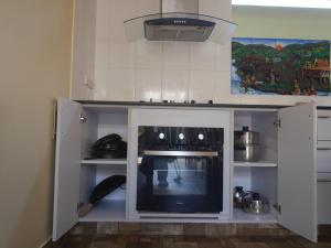 a kitchen with a stove and a tv in it at Villa family in Ban Saiyuan (1)