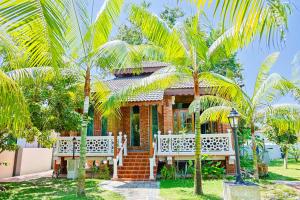 a house with palm trees in front of it at DAWA Brickhouse - Balinese Guesthouse in Thompson Ipoh by Ryokan Management in Ipoh