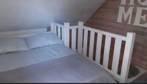 a white bed in a room with a crib at Kameralny domek in Borsk