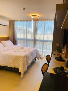 Un dormitorio con una cama y una ventana grande. en Alta Marine flat 304, en João Pessoa