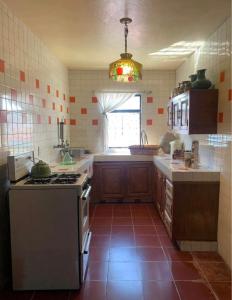 een grote keuken met een fornuis en een raam bij Habitación in Morelia