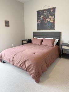 a bedroom with a large bed with pink sheets at 2Bd Twilight Retreat near Silos, Clemson & Greenville in Easley