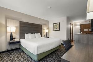 a hotel room with a large bed and a desk at Best Western Crown Inn & Suites - Batavia in Batavia +28 photos