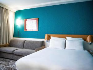 ein Hotelzimmer mit einem Bett und einer Couch in der Unterkunft Hotel Novotel Evry Courcouronnes in Courcouronnes + 109 Fotos