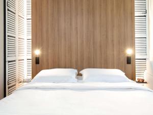 1 dormitorio con 2 camas blancas y 2 ventanas en Mercure Aix en Provence Beaumanoir, en Aix-en-Provence