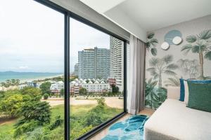 a room with a large window with a view of the ocean at Pattaya Marriott Resort and Spa in Jomtien Beach +95 photos