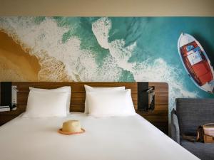 un lit avec un chapeau installé au-dessus dans l'établissement Novotel Antibes Sophia Antipolis, à Valbonne